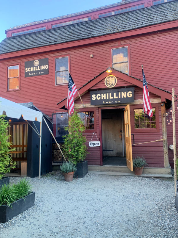 Schilling beer co. a red building with 2 flags on the front door