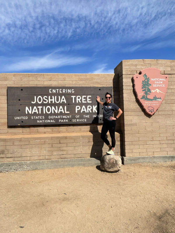 Me standing on a rock in front of the Joshua Tree visitor sign